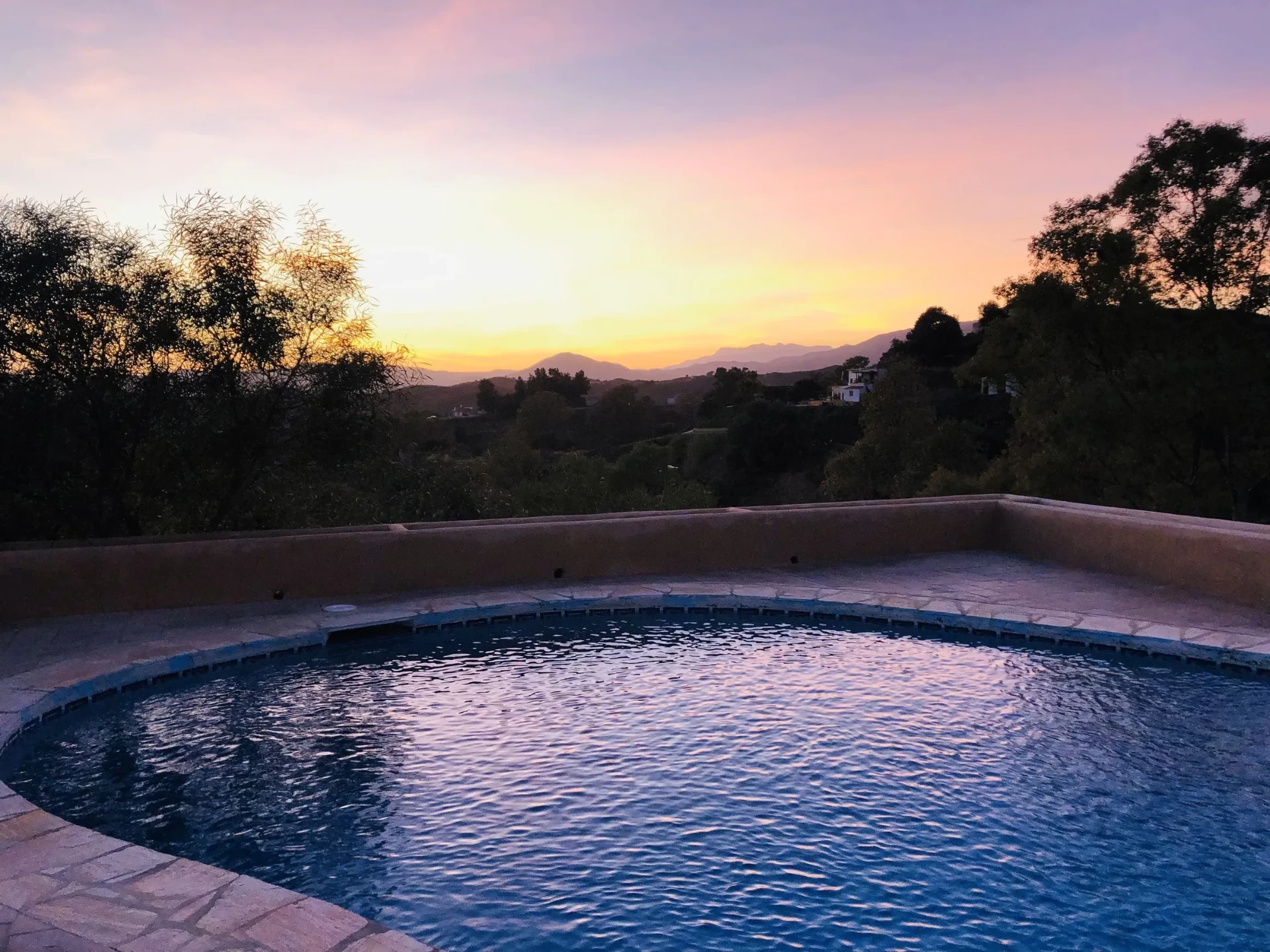 The salt-water pool at House of Inquiry at sunset, with the mountains behind
