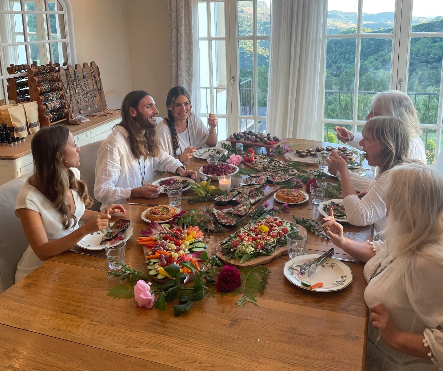 Guests sharing a generous spread of colourful dishes around a long wooden table