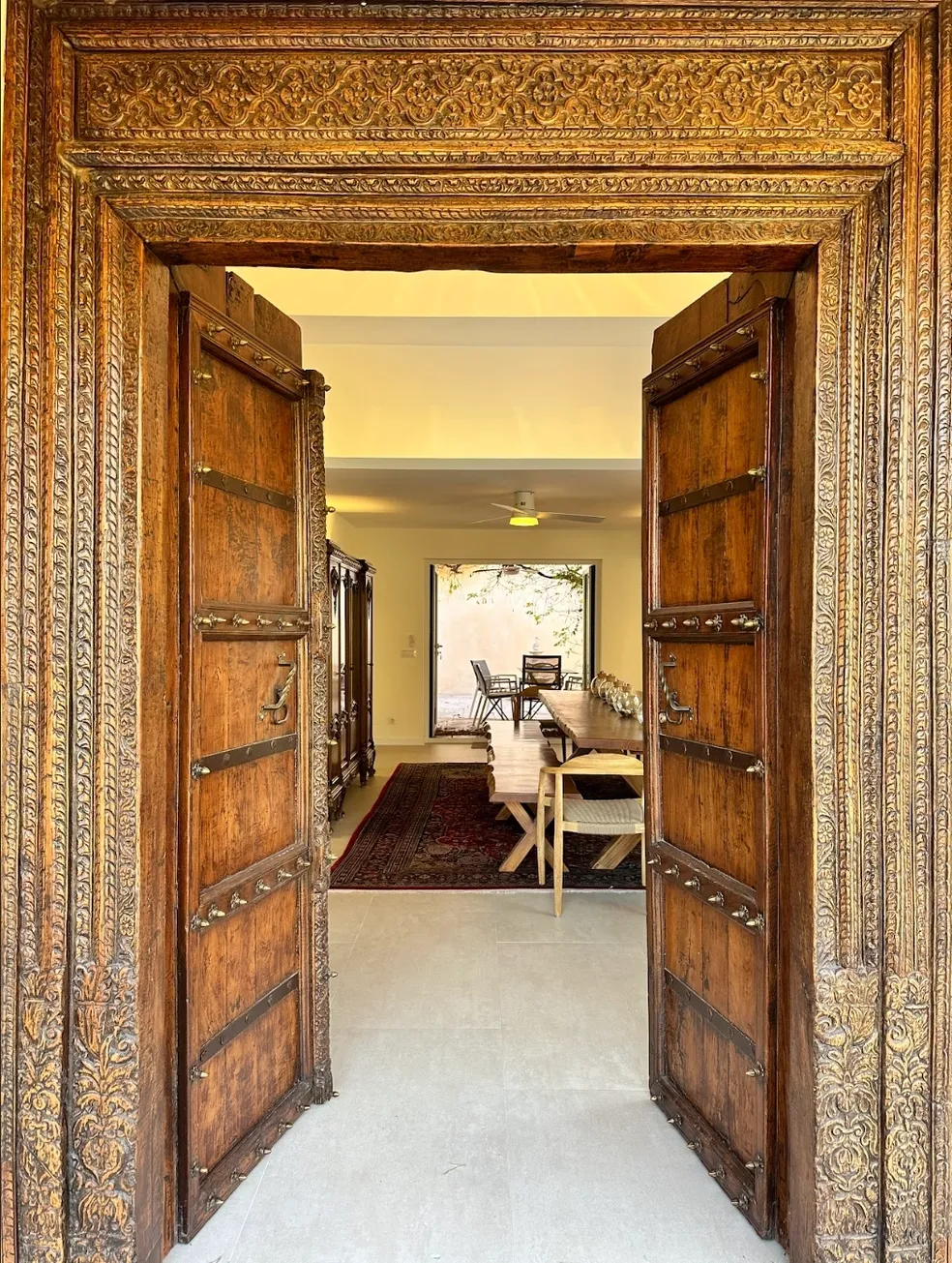 The carved entrance doors and long dining table at House of Inquiry